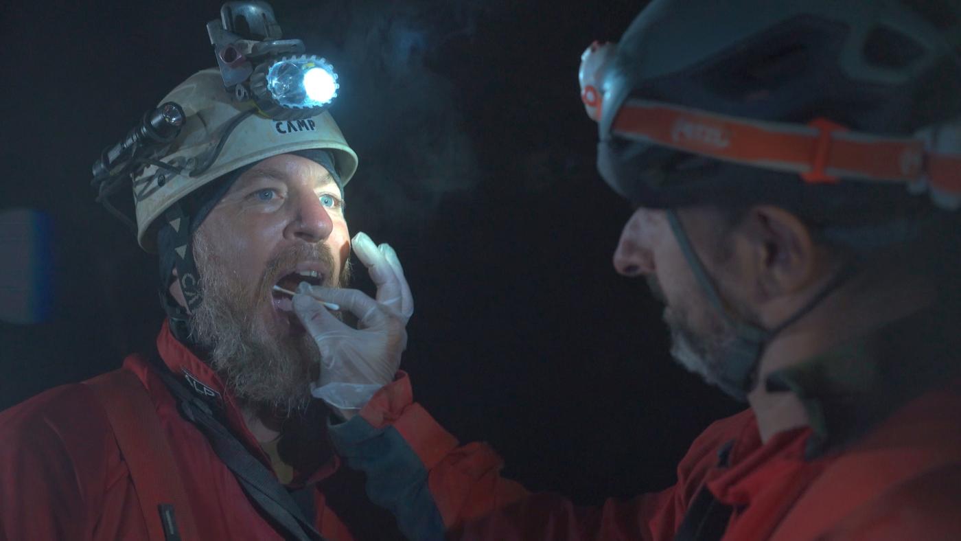 Collecting a saliva sample from a caver underground